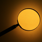 Photo of magnifying glass on yellowish background